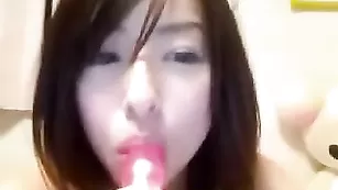 Азиатка трахает свою мохнатку вибратором