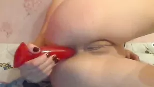 Смазливая красотка трахает очко красным дилдо