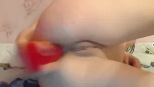 Смазливая красотка трахает очко красным дилдо